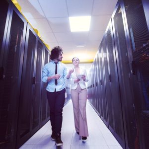 engineer showing working data center server room to female chief