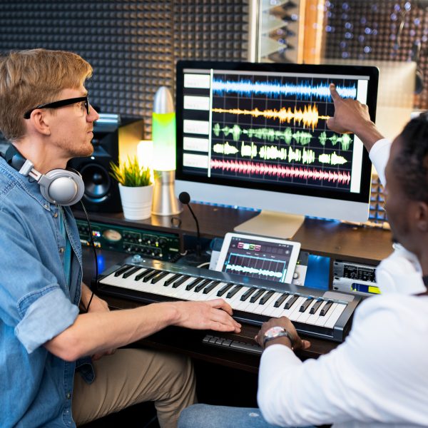 One of contemporary musicians pointing at sound waveform on computer screen