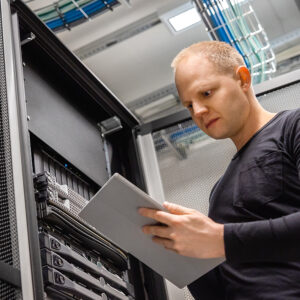 Male IT Professional Using Digital Tablet to Monitor Datacenter Status